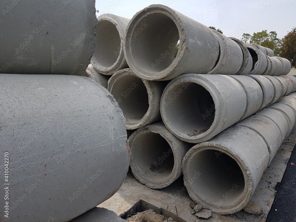 Large cement drains piled along the roadside. Large cement drains piled along the roadside.