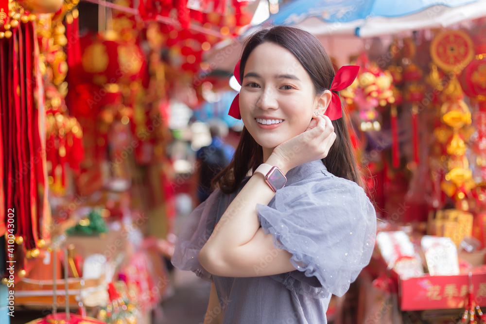 Asian beautiful woman in long hair wears a grey Chinese dress with Chinese new year theme. Asian beautiful woman in long hair wears a grey Chinese dress with Chinese new year theme.