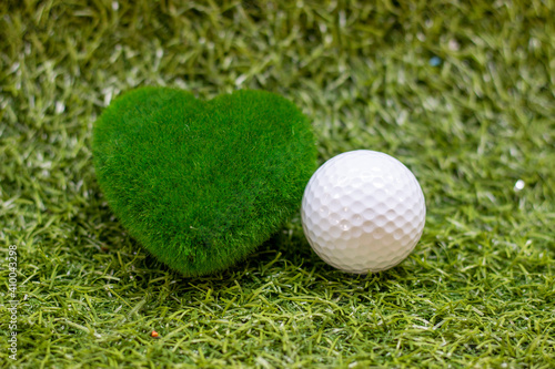 Golf ball with heart grass shape is on green grass