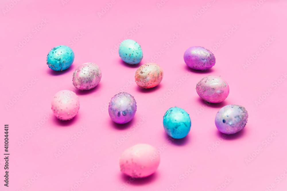 Group of Easter eggs with space galactic pattern on a pink background a filler in the form of a pink nest on a magenta background. flat lay with an easer cake inside