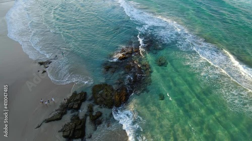 Tourists At The Beach Watching Sea Waves Crashing In Rocky Outcrops - Secluded Beach - Point Lookout, Queensland, Australia. - aerial photo