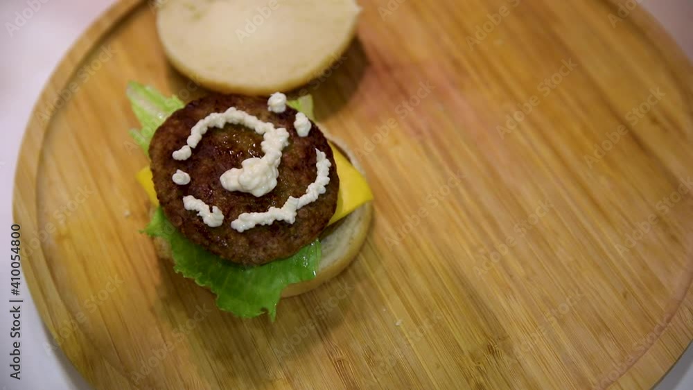 Slow Motion-Brunette skin woman with red nail polish is squeezing mayonnaise onto hamburger meat Slow Motion-Brunette skin woman with red nail polish is squeezing mayonnaise onto hamburger meat