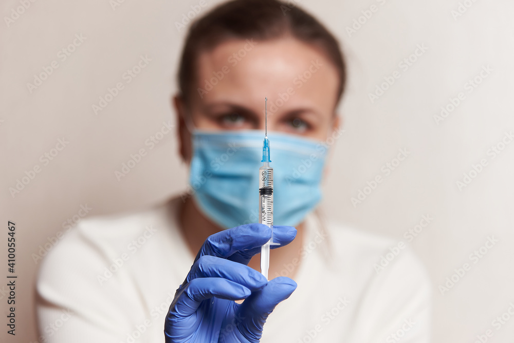 a woman holds an injection syringe in front of her. Vaccination in a pandemic a woman holds an injection syringe in front of her. Vaccination in a pandemic