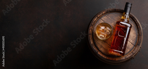 Scotch whiskey bottle, glass and old barrel