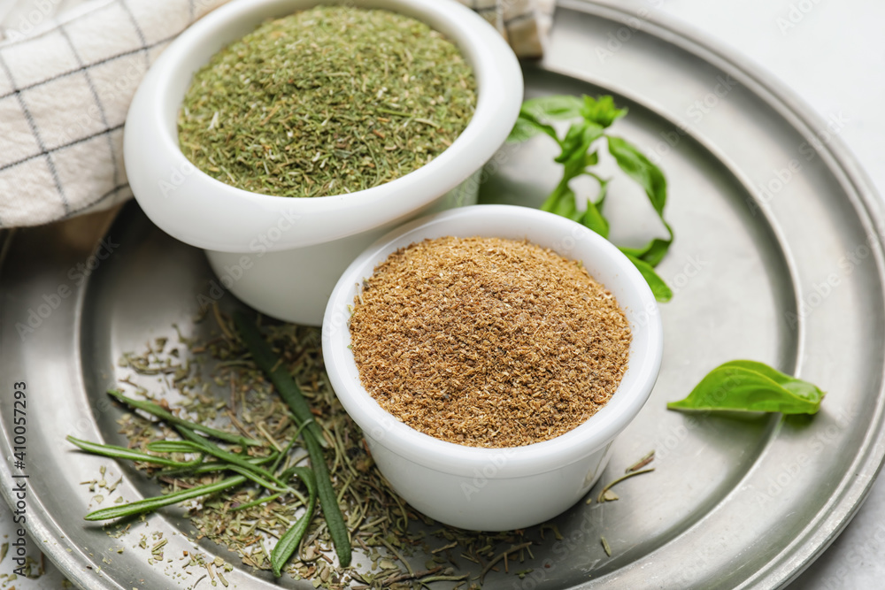 Tray with different spices and herbs on light background, closeup Tray with different spices and herbs on light background, closeup