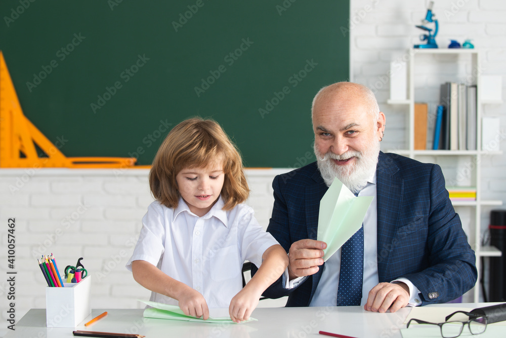 Happy kid in school. Teacher with pupil with airplanes. Education, teachering, elementary school. Happy kid in school. Teacher with pupil with airplanes. Education, teachering, elementary school.