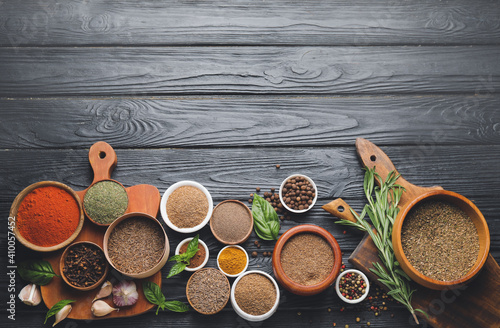 Different spices and herbs on dark wooden background