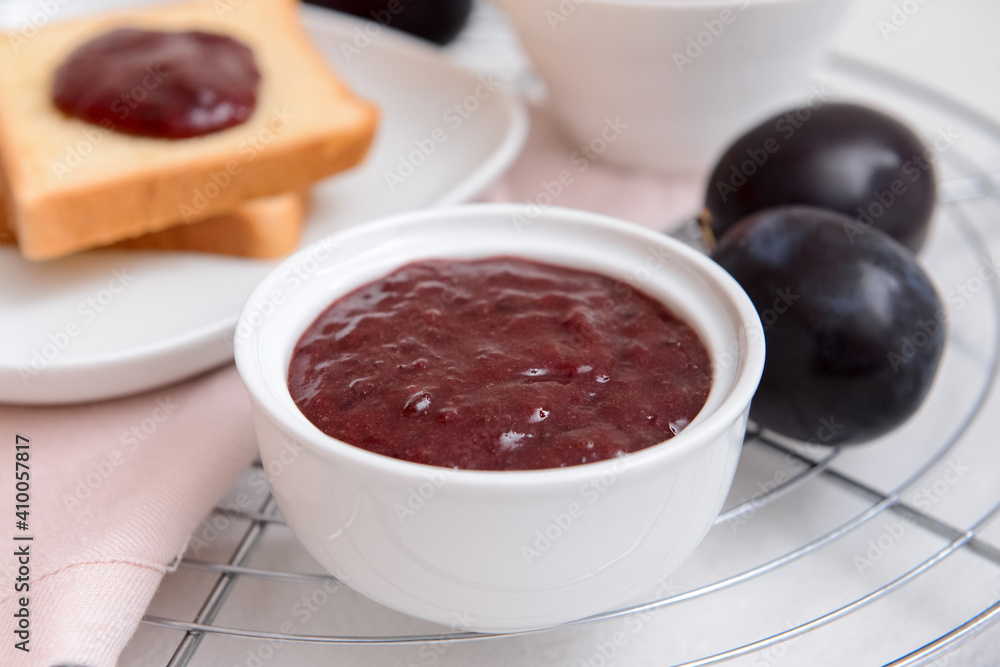 Bowl with delicious homemade plum jam on light background Bowl with delicious homemade plum jam on light background