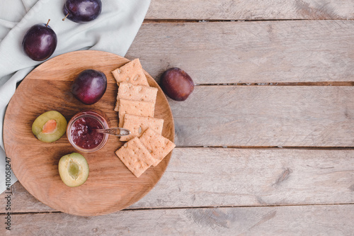 Composition with delicious homemade plum jam on wooden background