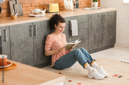 Young woman reading book in...