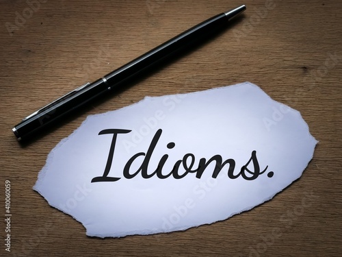 Photography Selective focus top view text Idioms written on a piece of paper with a pen