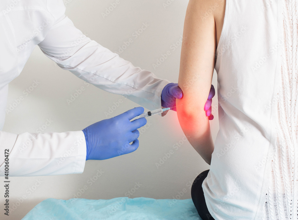The doctor gives the patient an injection intraosseous medical blockade to relieve pain in case of rupture of ligaments and fracture of the elbow joint, therapy The doctor gives the patient an injection intraosseous medical blockade to relieve pain in case of rupture of ligaments and fracture of the elbow joint, therapy