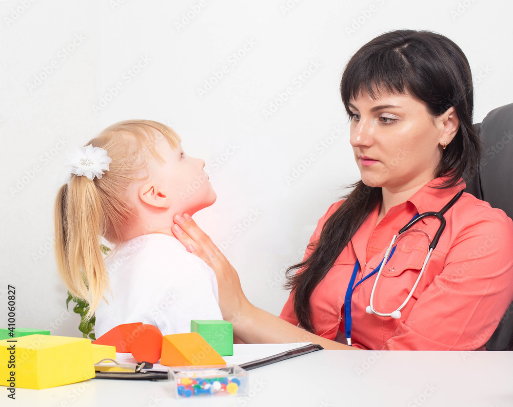 A pediatric otolaryngologist doctor probes the tonsils on the throat of a little girl 3 years old. The concept of sore throat in children and the treatment of diseases of laryngitis and tonsillitis