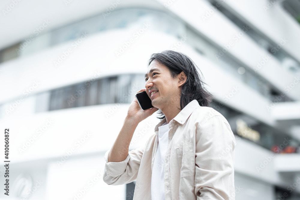 Happy Japanese man talking on his smartphone