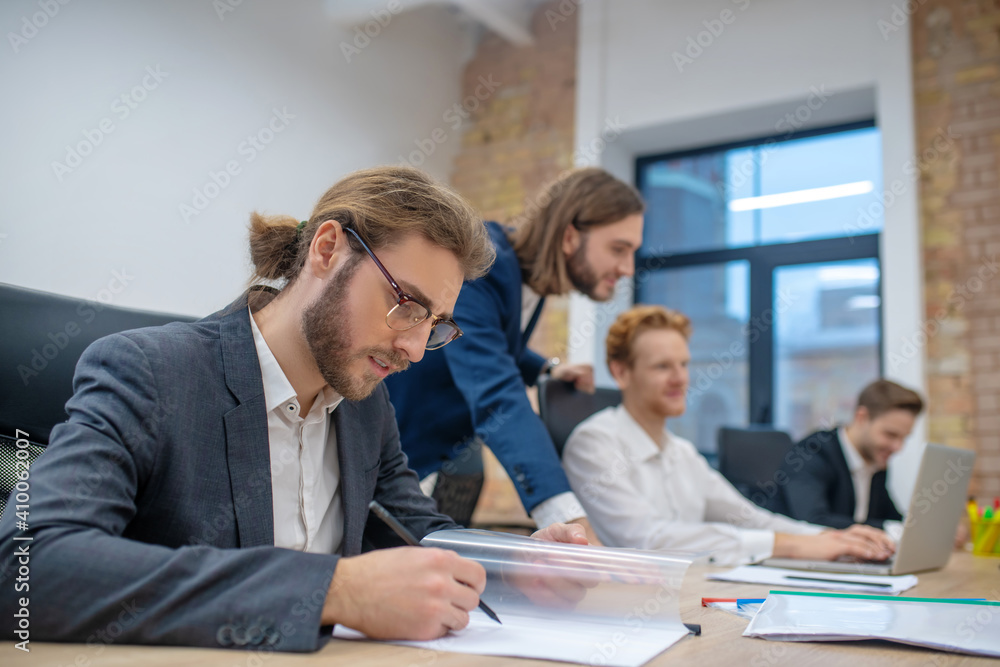 Man in glasses with pencil looking at document Man in glasses with pencil looking at document