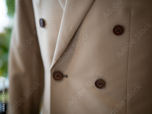 Close up of beige suit jacket with tuxedo white shirt and vintage bow detail