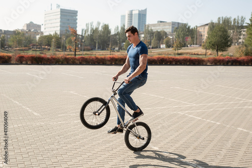Teenage BMX rider is performing tricks in skatepark
