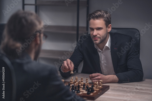 Smiling smart man with chess piece in hand