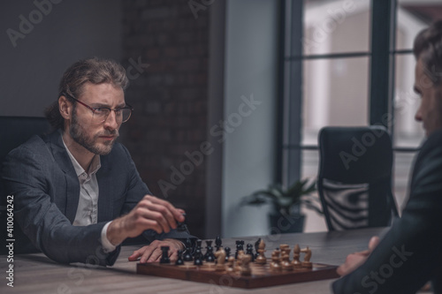 Man with chess piece looking at opponent