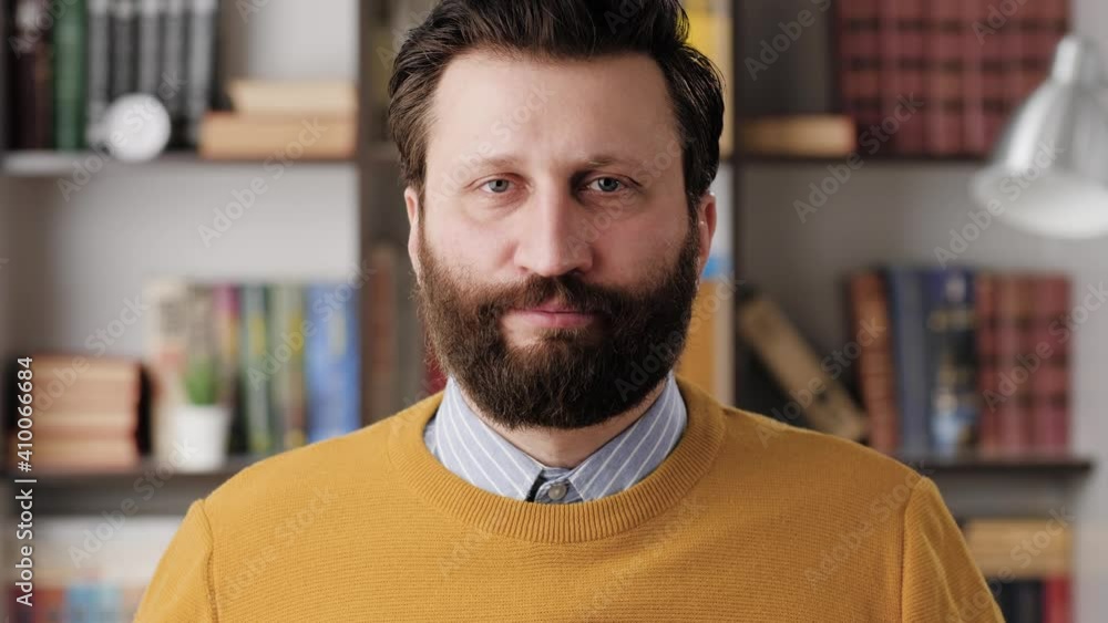FACEPALM. Astonished bearded man in glasses in office or apartment room looks at camera and covers his face with his hands expressing his bewilderment. Close-up and slow motion