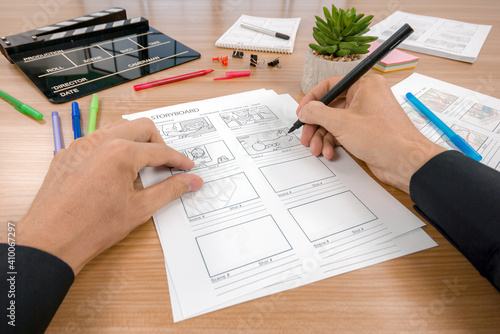 Photos Hand with writing storyboard with clapperboard to present process to make movie