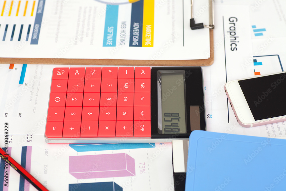 Financial information, calculator and mobile phone on the desk