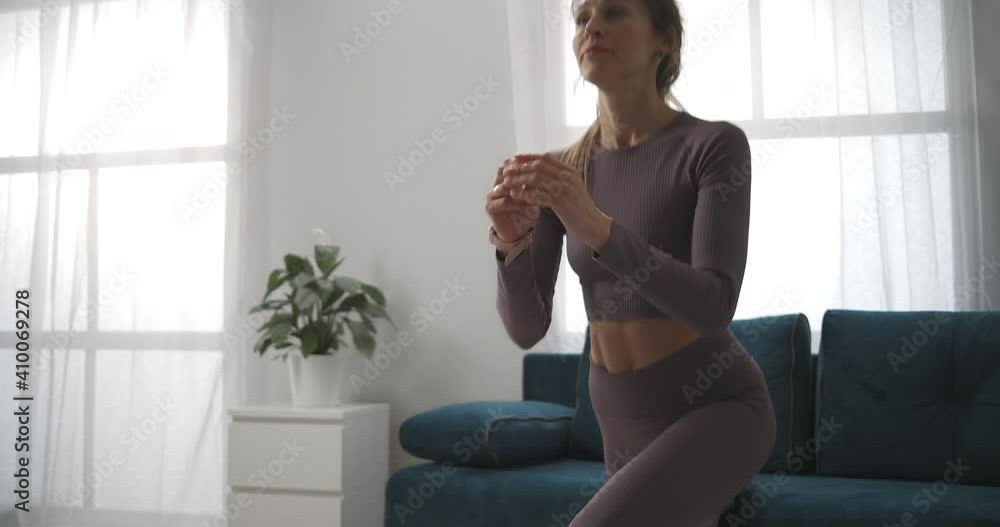 young woman is training fitness at home, squatting for beautiful body, physical activity and healthy lifestyle, medium shot young woman is training fitness at home, squatting for beautiful body, physical activity and healthy lifestyle, medium shot