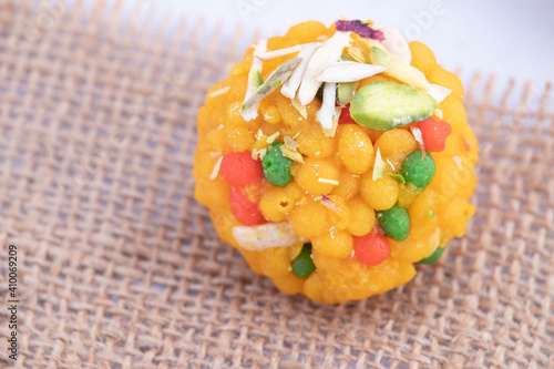 Top View Of Single Piece Indian Mithai Jodhpuri Ladoo Laddu Also Called Boondi Or Bundi Ladoo On Burlap Jute Fabric. Meetha Laddoo Is Made Of Bengal Gram Flour Deep Fried In Shuddha Desi Ghee photo