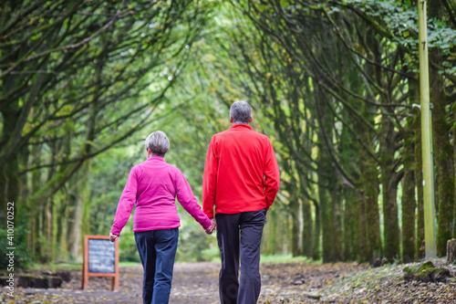 Beautiful older couple holding hand each other and walking in the park.