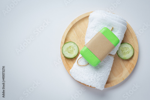 Cucumber slices and soap on white background