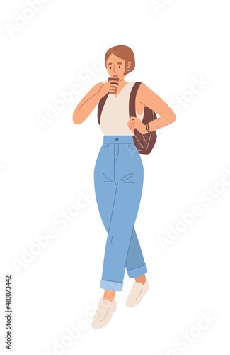 Modern young woman drinking coffee from disposable paper cup on the move to w...