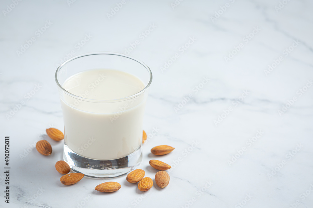 Almond milk with almond on marble background