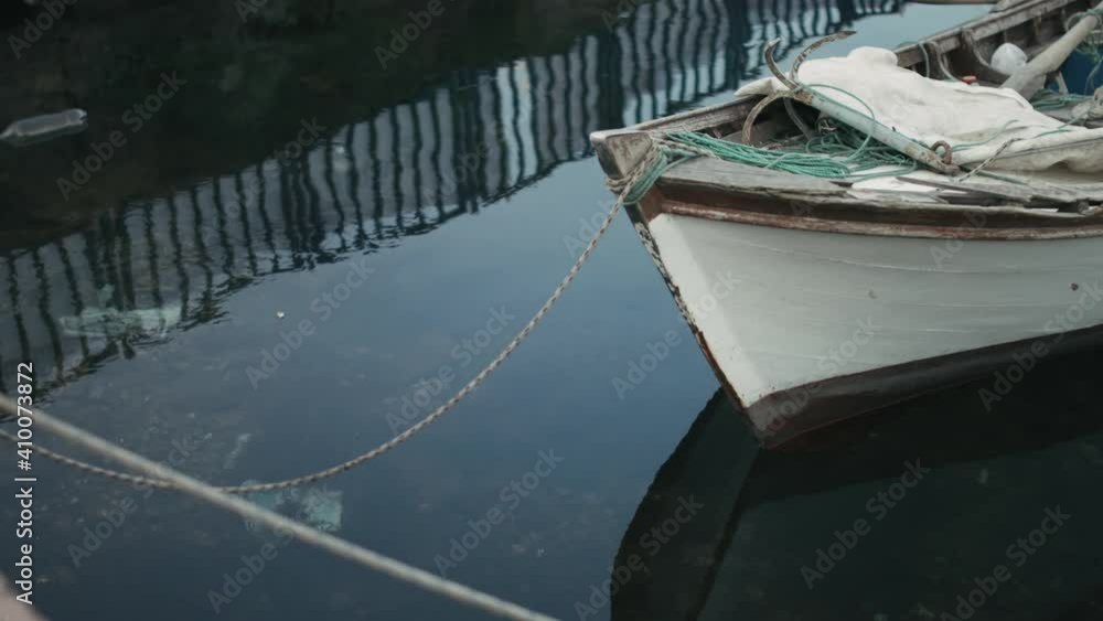 Old and Worn Out Crusted Wooden Boat, Tied to Pier with Rope, Waving up and Down with Sea Water in slowmo Old and Worn Out Crusted Wooden Boat, Tied to Pier with Rope, Waving up and Down with Sea Water in slowmo