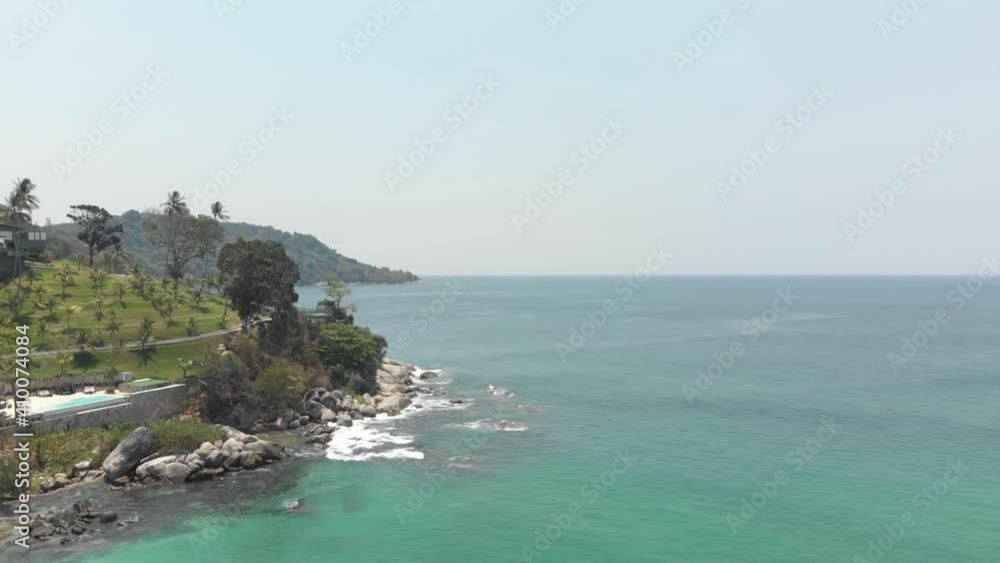 Rocky landscape meeting the Andaman sea parallaxing with the other shoreline - Aerial Low angle slide shot Rocky landscape meeting the Andaman sea parallaxing with the other shoreline - Aerial Low angle slide shot