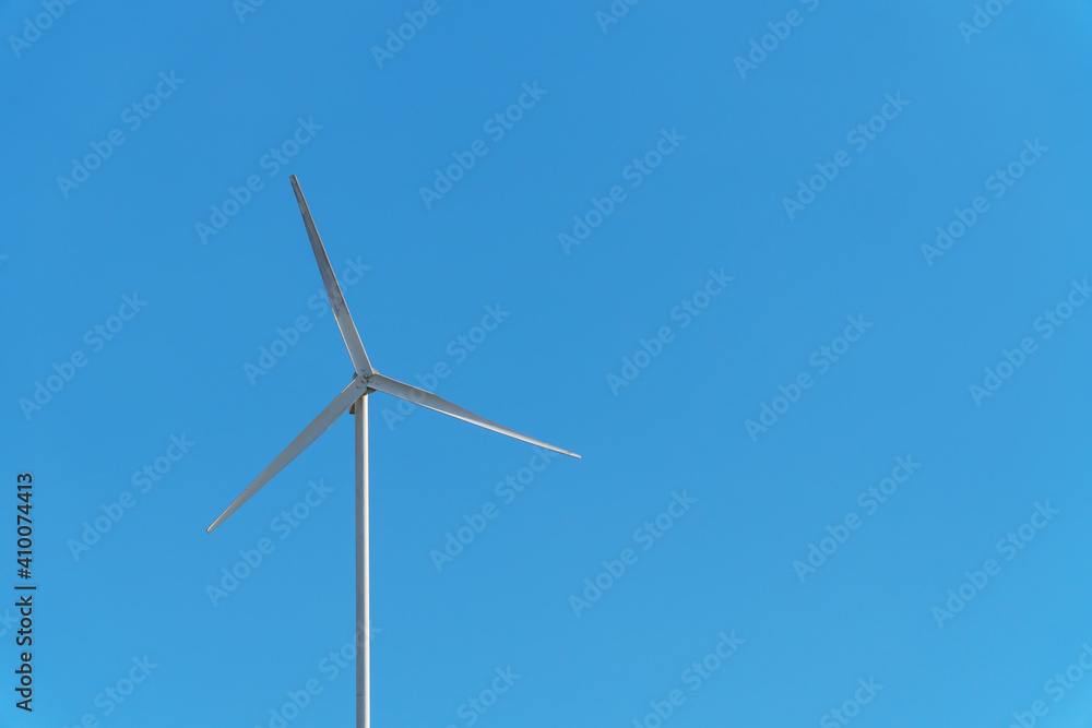 A small wind white turbine with a sky as a background. A small wind white turbine with a sky as a background.