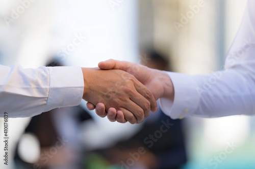 Close up, Handshake of two businessmen on the background of modern office, Shaking hands to seal a deal