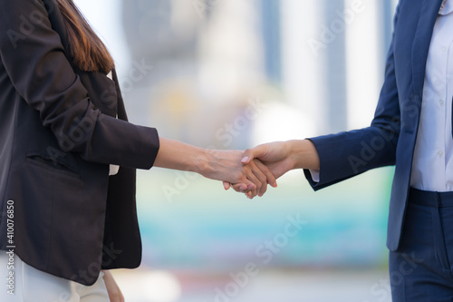 Close up, Handshake of two business women on the background of modern office, Shaking hands to seal a deal