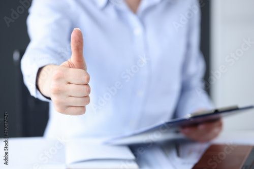 Female hand showing OK gesture in office closeup