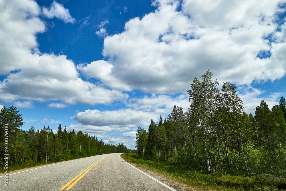 View from relief car windscreen on the blue sky with white clouds, grey asphalt road and landscape with forest and green teeses. Landscape through window View from relief car windscreen on the blue sky with white clouds, grey asphalt road and landscape with forest and green teeses. Landscape through window