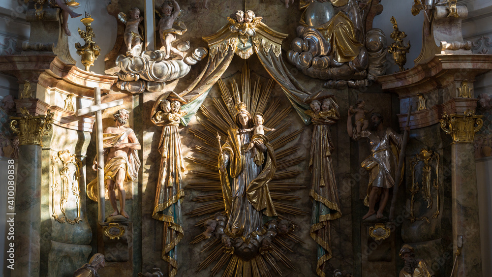 Religious sculptures illuminated by a sunray. With mary and her child Jesus. Inside the church St. Alto und St. Birgitta.