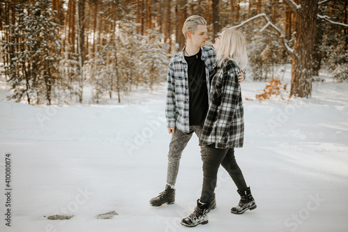 Сouple walking and kissing in the winter forest with snow

