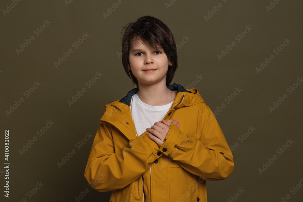 Calm little boy holding hands on chest close to heart feel grateful, thanking fate. Gratitude concept Calm little boy holding hands on chest close to heart feel grateful, thanking fate. Gratitude concept