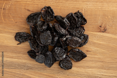 Pile of prunes, dry plums isolated on wood background.