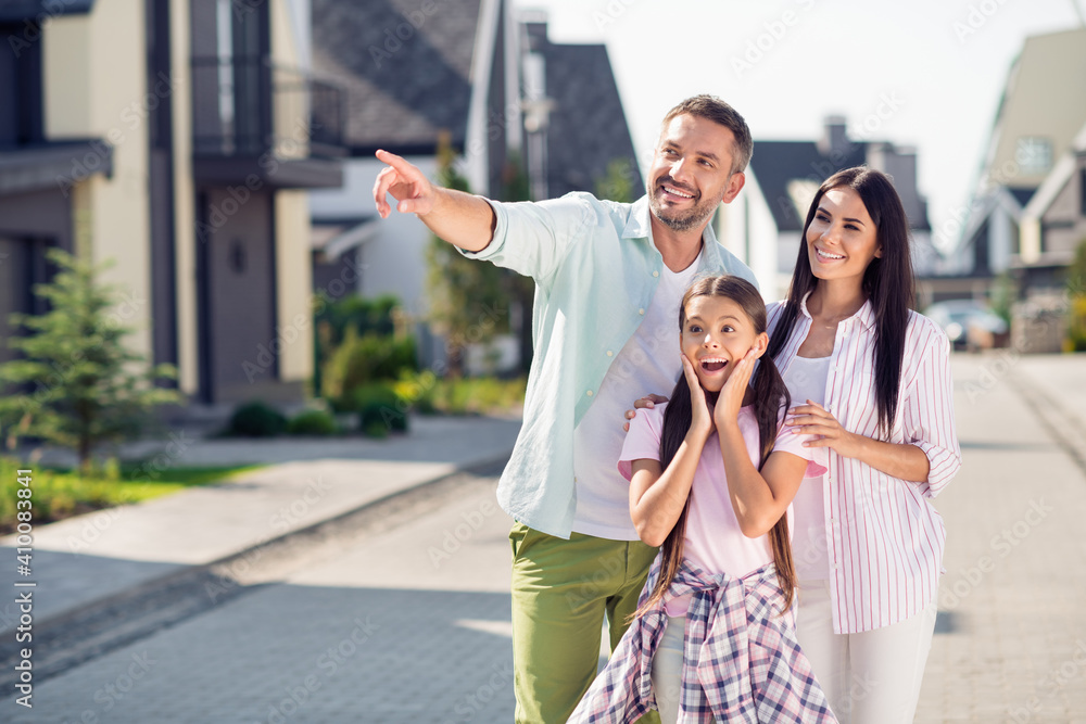 Photo of happy cheerful excited smiling family outside dad point finger copyspace mom and child girl look copyspace Photo of happy cheerful excited smiling family outside dad point finger copyspace mom and child girl look copyspace
