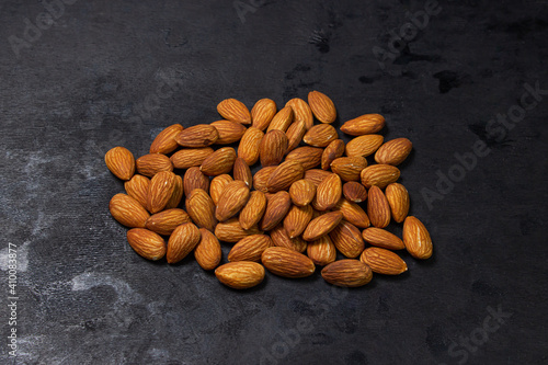 Almonds on a black background. Isolated almonds. Small pile of roasted almonds