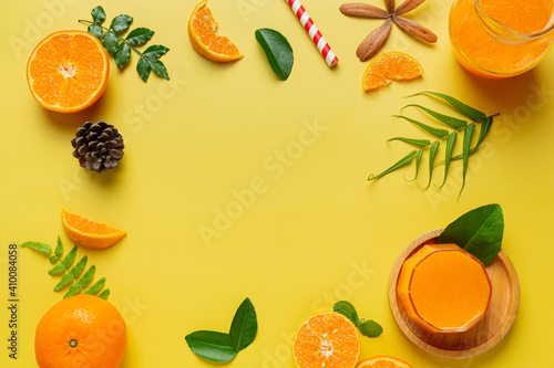 Fresh orange juice in the glass on yellow background