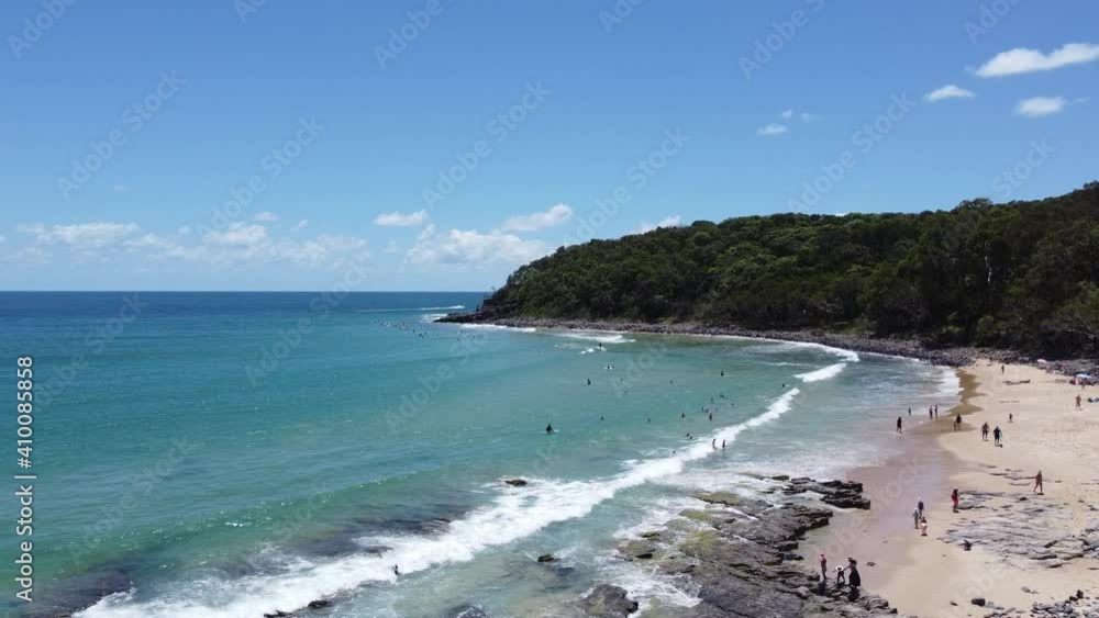 Drone ascending on a beautiful beach with surfers in the background Drone ascending on a beautiful beach with surfers in the background