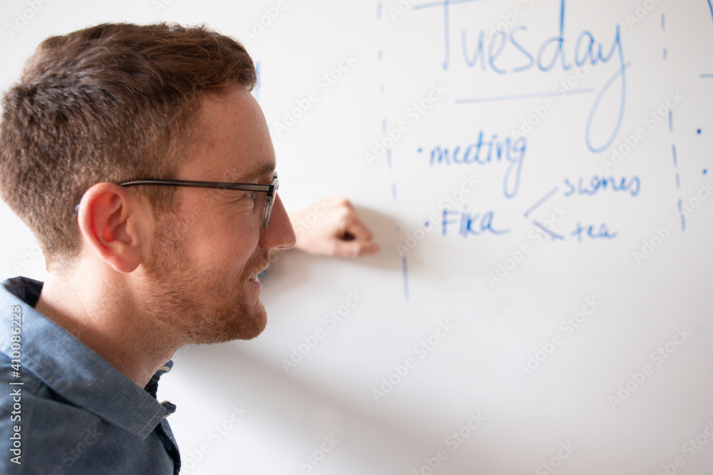 Smiling man standing in front of whiteboard