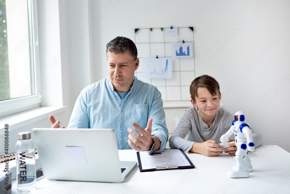 Stay at home, work from home concept during coronavirus pandemic. Father with kid working from home during quarantine.