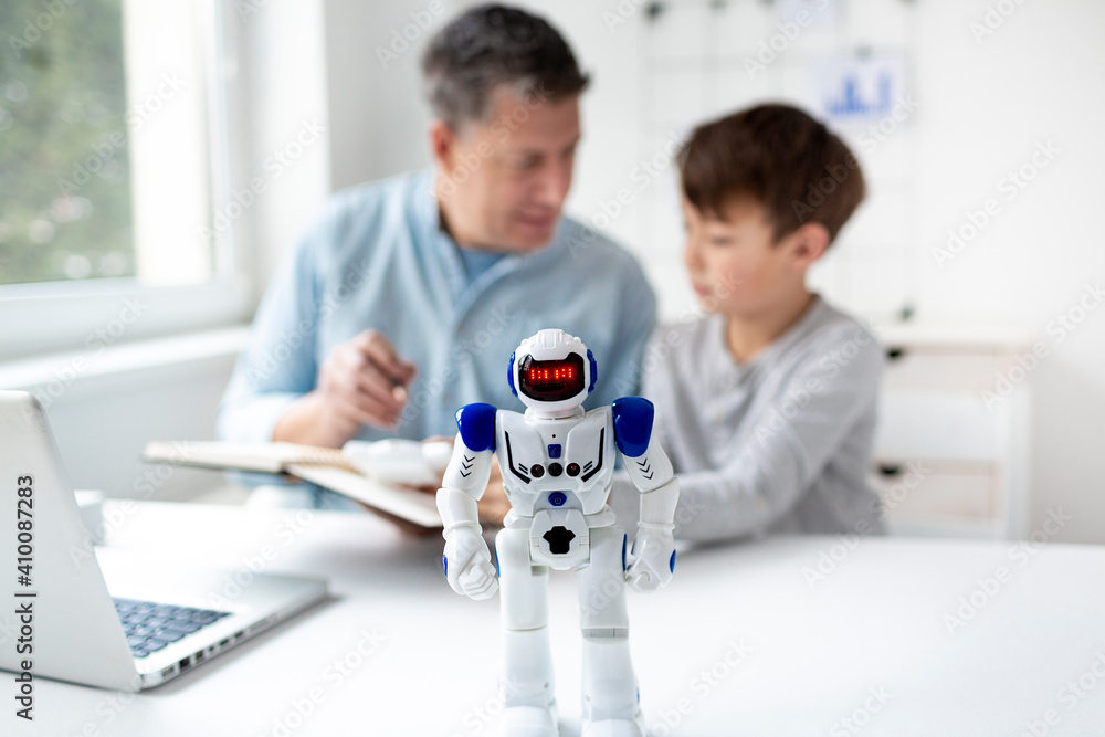 © epiximages - Technology concept. Parent and son working and playing with a robot. © epiximages - Technology concept. Parent and son working and playing with a robot.